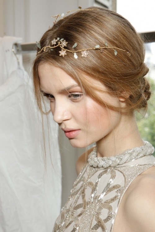 a delicate and a bit messy updo with a refined embellished floral crown is a stylish idea for a modern beach bride with a romantic feel