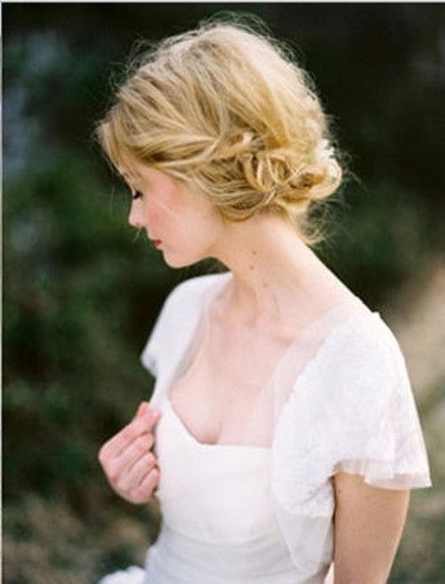 a messy braided and woven updo with a bit of texture on top and some white blooms is a chic and cool idea for a beach bride