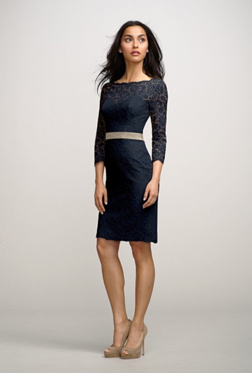 a black lace over the knee dress with a high neckline, long sleeves and a nude sash plus nude shoes for a refined and chic look