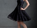 a black lace sleeveleess A-line bridesmaid dress with an illusion neckline and lacey shoes for a stylish bridesmaid look