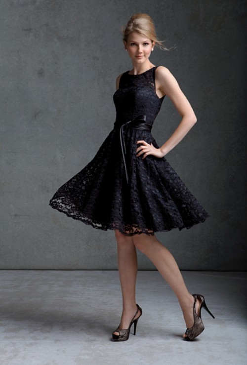 a black lace sleeveleess A-line bridesmaid dress with an illusion neckline and lacey shoes for a stylish bridesmaid look