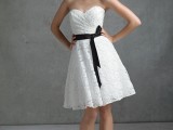 a strapless white lace A-line bridesmaid dress with a draped bodice and a black sash feels retro and looks cute and cool