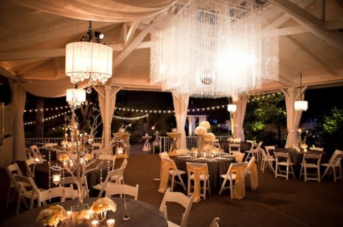 white chandeliers with crystals hanging down from lampshades and an oversizedsquare crystal chandelier as a centerpiece