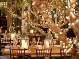 trees covered with lights and candle lanterns create a magical atmosphere and a cozy feel