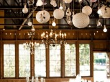 a creative chandelier with various bulbs hanging and paper lamps and vintage chandeliers light up the space in a cool way