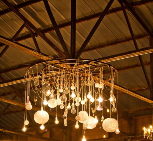 a whimsical chandelier with lots of various bulbs is a cool decoration and a lighting piece for a rustic venue
