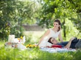 a simple and cute wedding picnic with colorful blankets, candles and bright blooms for a summer celebration