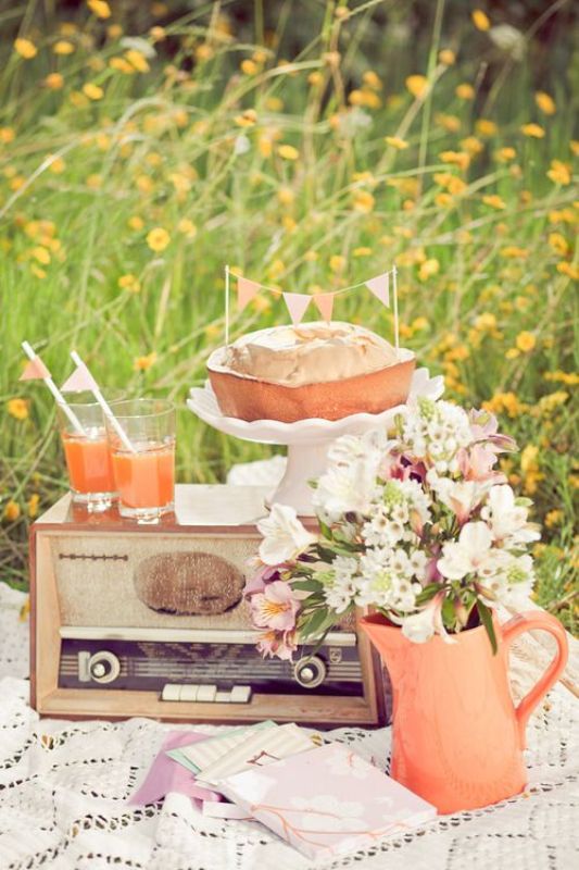 A retro wedding picnic with a lace blanket, pastel blooms, a vintage radio, a pie and juice for a summer wedding