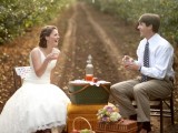 a garden wedding picnic with a paper lamp garland, chairs, basket boxes and some apples and apple cider