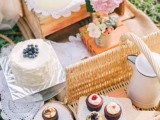 a rustic summer wedding picnic setting with crates, baskets, bright blooms, delicious sweets, lemonade and tea and coffee