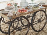 a vintage rustic dessert cart decorated with blooms in jars and styled with crystal cake and dessert stands