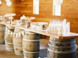 a rustic dessert and drink display of wine barrels and a tabletop on them, various sweets and milk bottles