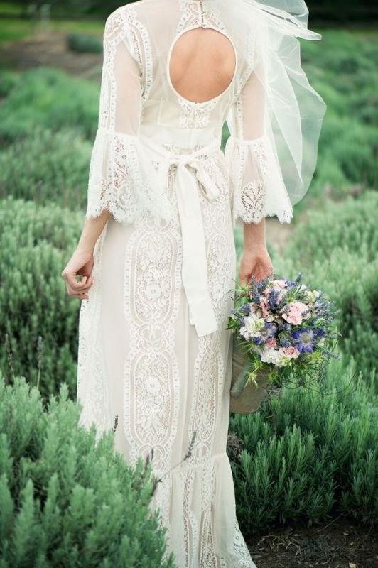 A whimsy fitting lace wedding dress with a keyhole back, short bell sleeves and a bow