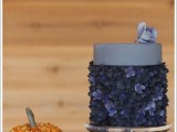 an eye-catchy dark wedding cake with a sleek top tier and a dark flower lower tier plus a bloom on top is a lovely idea for a modern dark wedding