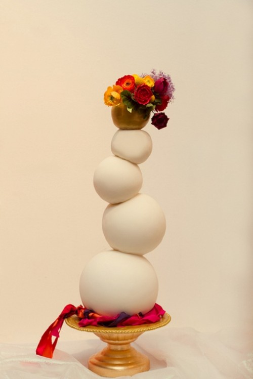 a weird stacked ball wedding cake with a bit of bold fresh blooms on top is a lovely idea for a whimsical wedding