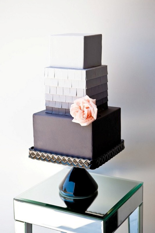 An elegant and sleek square wedding cake with a white, ombre and black tier, with a bit of fringe and a fresh blush bloom is a stylish idea