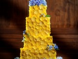a yellow floral wedding cake decorated with fresh blue blooms is a catchy idea for a spring or summer wedding done in a bold color palette