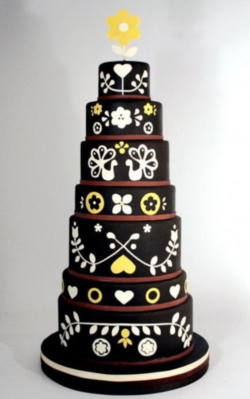 a black, white and yellow wedding cake with patterns and flora and fauna prints is a catchy idea for a modern and bold wedding