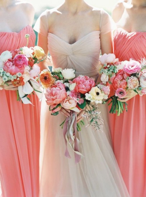 colorful wedding bouquets with orange ranunculus, pink peonies, white and pastel anemons and greenery for a colorful summer wedding