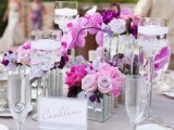 a bright radiant orchid and pink wedding centerpiece with candles and mirror vases is amazing