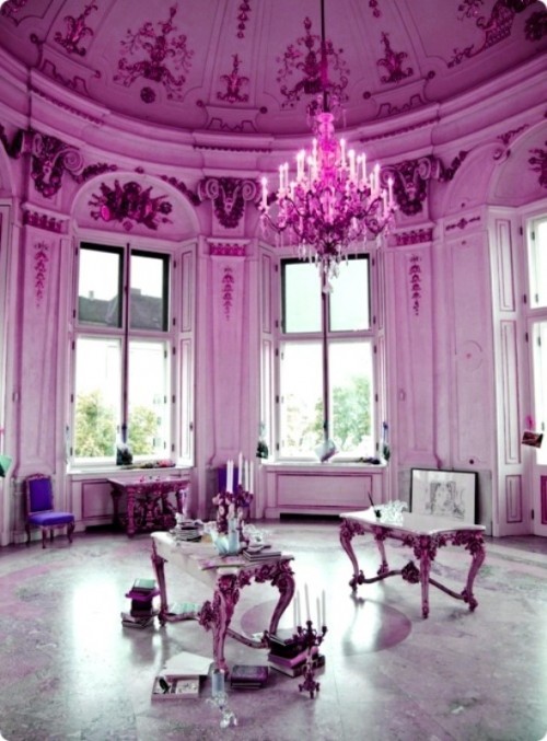 a radiant orchid hall with a crystal chandelier, some refined and cool furniture and candles is a unique space to choose for your wedding