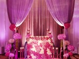 a radiant orchid wedding altar with blooms, candles, radiant orchid curtains and blooms plus lights