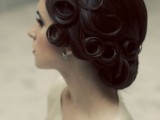 a vintage updo with curls that are fixed to stay in place shows off a modern take on a vintage hairstyle