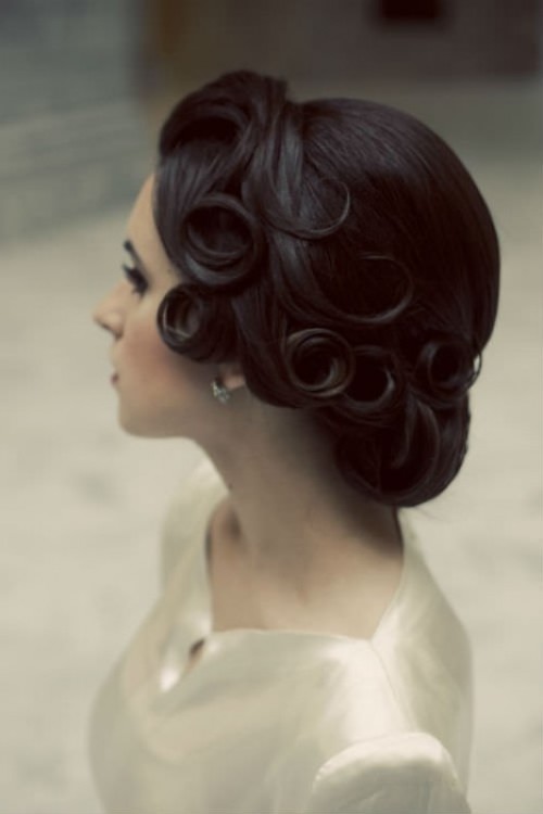 a vintage updo with curls that are fixed to stay in place shows off a modern take on a vintage hairstyle