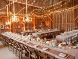 rustic wooden tables with neutral fabric runners, white candles and white bloom centerpieces