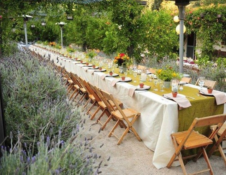 a wide mustard table runner contrasts the neutral tablecloth and bright bloom centerpieces add color
