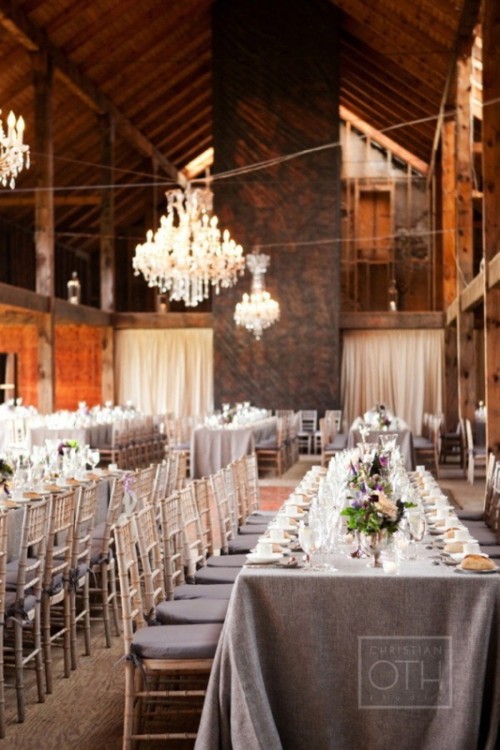 a grey tablecloth and colorful bloom centerpieces plus grey cushions on the chairs