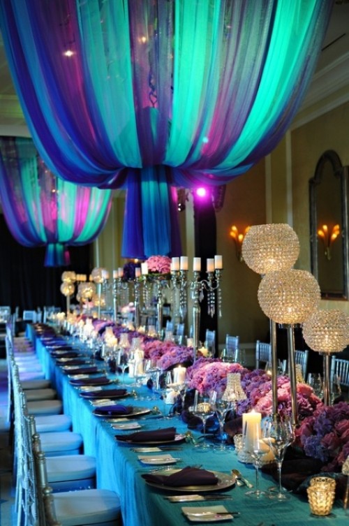 purple floral centerpieces and a turquoise tablecloth are combined with curtain lamps of the same colors