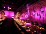candles and purple blooms match the purple backdrop in the reception space