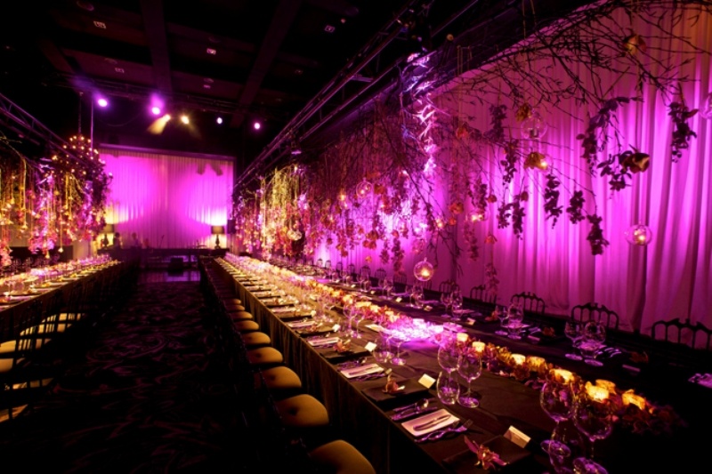 Candles and purple blooms match the purple backdrop in the reception space
