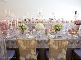 a grey lace tblecloth and neutral lace chair covers plus lush floral centerpieces