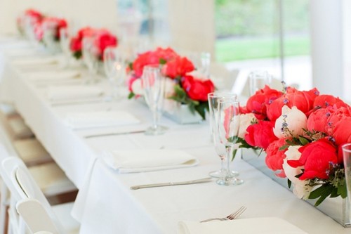 long colorful floral centerpieces contrast the neutral tables