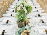 a white tablecloth, a light green table runner, branch candle holders refresh the tablescape