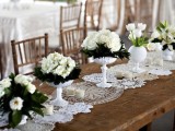 a neutral doily table runner paired with lush white floral centerpieces for a vintage chic feel at the table
