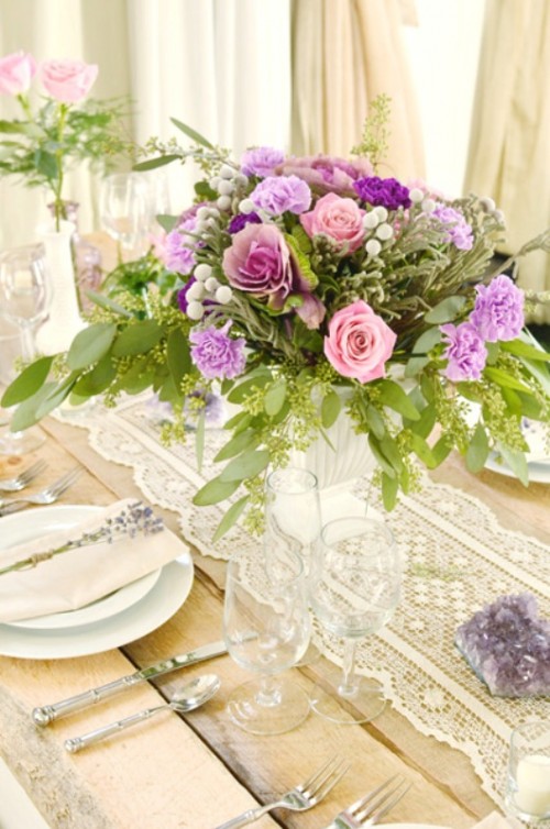an elegant white lace wedding table runner and bright contrasting flowers for a vintage wedding