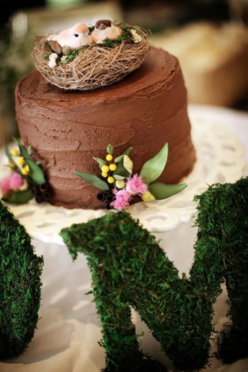 a chocolate buttercream wedding cake with bold blooms and greenery and a nest with faux birds is a lovely idea for a modern wedding