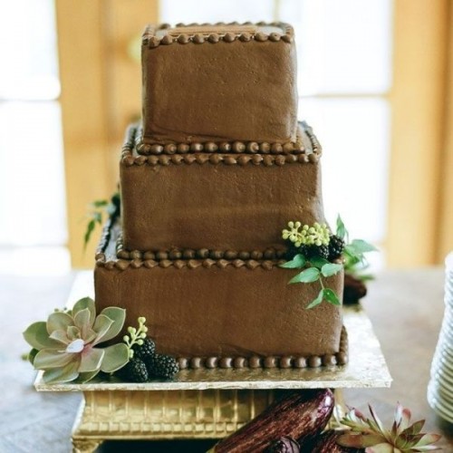 a square chocolate wedding cake with beads, berries, greenery and succulents is a lovely idea for many weddings, it can fit many styles