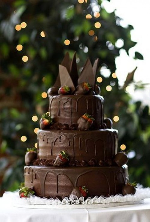 a chocolate wedding cake with chocolate drip, chocolate shards and chocolate dipped strawberries is a fantastic and indulging dessert for a wedding