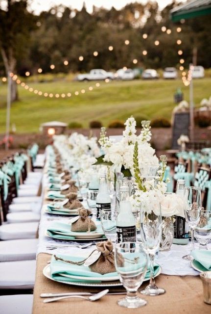 a rustic tablescape done in mint and burlap, with white blooms and candles
