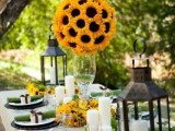 a rustic tablescape with lanterns and sunflowers plus moss and green napkins