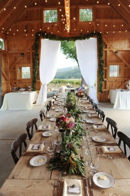 a rustic table setting with colorful bloom and greenery centerpieces and an uncovered table