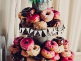a simple rustic wedding dessert stand of wood slices and tree stumps, with colorful paper banners and lots of sweets