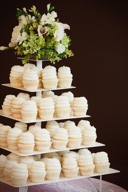 a sleek white metal stand with cupcakes and blooms and greenery on top is a lovely idea to rock at any modern wedding