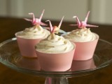 cupcakes with frosting and pink liners and pink origami cranes on top are amazing for a wedding with pink in the color scheme