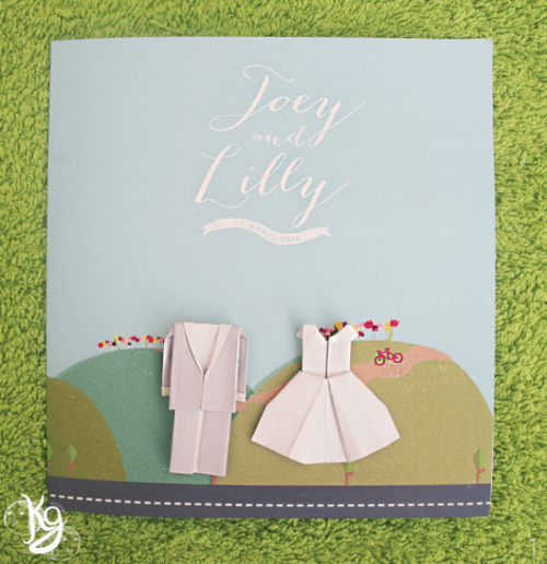 a colorful wedding invitation with origami couple outfits for fun decor and to hint that your wedding gonna be fun