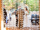 a stained wedding arch with white origami cranes hanging is a gorgeous idea for a modern wedding with a bit of DIY